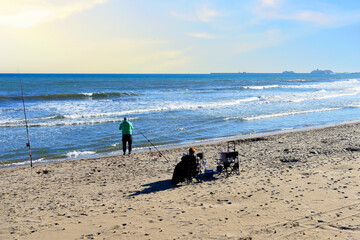 Fisherman catches fish on the coast near the sea. Catching fish in the sea from the shore. Fishing...