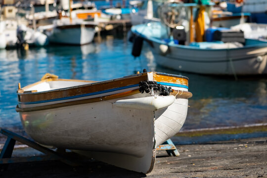 Colorful wooden fisher boat in the harbour Marina Grande on Capri Island Italy. Typical small rowing boats that bring tourists into the famous Blue Cave “Grotta Azzurra“, with blurred background.