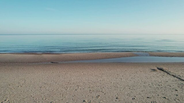 The camera slowly scrolls across the beach during sunrise.