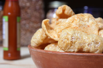 Fried Pork Skins With Hot Sauce in Rustic Kitchen