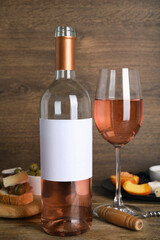 Delicious rose wine and snacks on wooden table