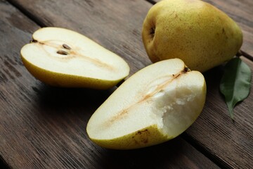 Naklejka na ściany i meble Whole and halves of tasty fresh pears on wooden table, closeup