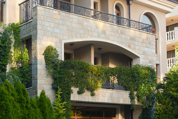 Fototapeta na wymiar Balcony decorated with beautiful green plants. Stylish exterior
