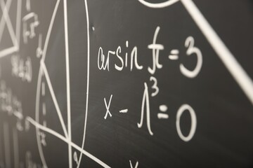 Fototapeta na wymiar Mathematical formulas written with chalk on blackboard, closeup