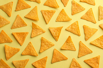 Flat lay composition of tortilla chips (nachos) on yellow background