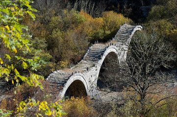Fototapeta na wymiar View of the traditional stone Kalogeriko or Plakida Bridge in Epirus, Greece in Autumn.