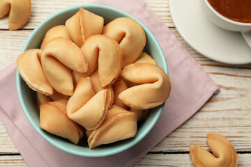 Tasty fortune cookies with predictions on white wooden table, flat lay