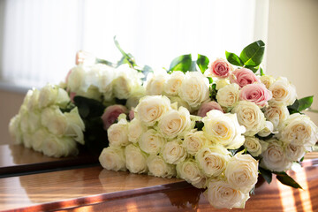 Bouquet of white roses that lie on the piano.