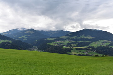 Fototapeta premium Alpen-Tal-Wolken-Wiese