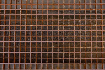 Close-up of the metal grating of the sewer drain, rusted with time. The infrastructure of a big city. sewer grate.