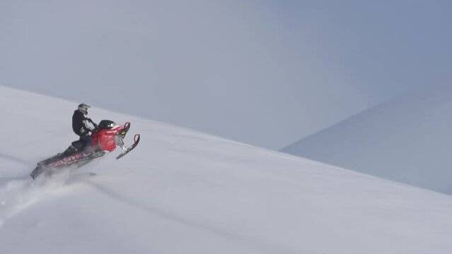 pro snowmobile extreme jump. 1000fps prores raw. on a clear background high in the mountains in flight on a mountain snowmobile