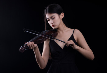 A young woman playing a violin on a black background