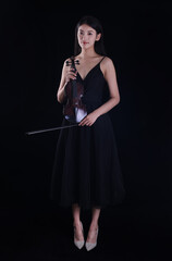A young woman playing a violin on a black background