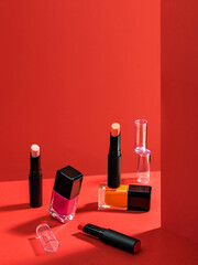 Composition with makeup products. Lipstick and nail polish. Cosmetic products advertisement on red background with Hard light. Product Advertising environment. Sale of beauty products concept..