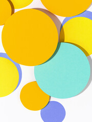Simple round shapes background in pastel blue and yellow colours. Fun bright coloured mosaic of paper circles. Creative conceptual template for styling and design. Mock up for text.