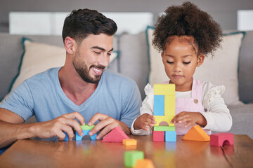 Father, adopted child and building blocks on table playing with little girl in living room at home....