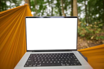 POV of working with a laptop remotely in the woods while hanging in a hammock. Modern laptop empty...
