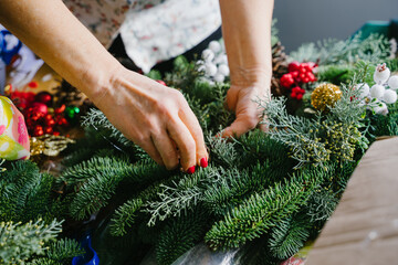 Creating a Christmas wreath. A wreath of coniferous branches with your own hands. Weaving a wreath with your own hands at a group master class. © Alice
