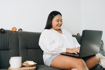 Portrait of a freelancer sitting on the couch and using laptop at home