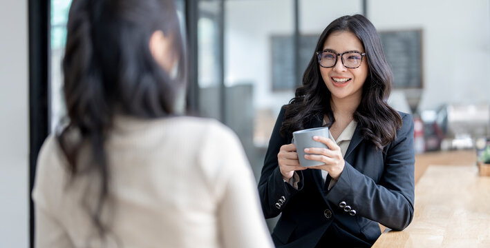 Young beautiful asian businesswoman having fun talking with her colleagues during a break from work. - Powered by Adobe
