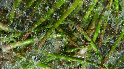 Freeze Motion Shot of Splashing Fresh Asparagus. Filmed on High Speed Cinematic Camera at 1000fps.