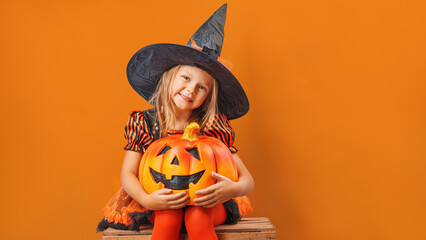  Happy little child girl in witch costumes and makeup having fun on Halloween celebration