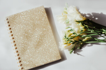 Diary notebook on the background of flowers and wooden figured boards.