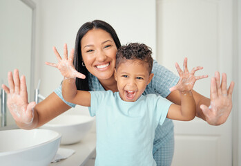 Mother and son in bathroom with clean hands, open palms that are cleaned and covered in foam teaching child hand washing. Cheerful parent help kid with hygiene for hand with water, soap and bubbles.