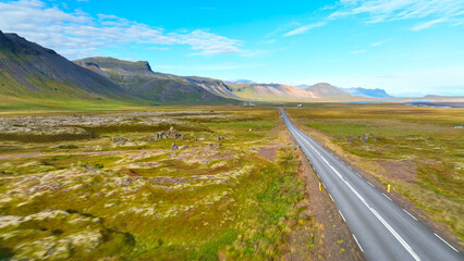 Aerial View Shot of car driving through volcanic land, Iceland, Europe.