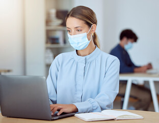 Laptop, face mask and corporate employee working on a project while sitting at a desk in the...