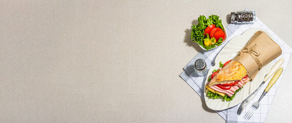 Panini sandwich with ham, crispy salad and vegetables. Healthy food to go concept, lunch or snack