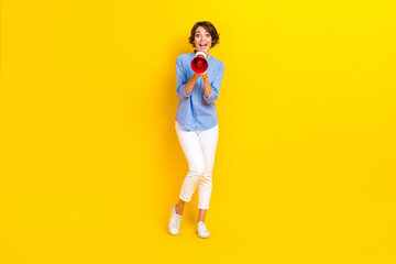 Fototapeta na wymiar Full length photo of funny excited girl dressed blue shirt screaming announcement isolated yellow color background
