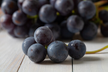 There is a bunch of grapes on the table. Macro.