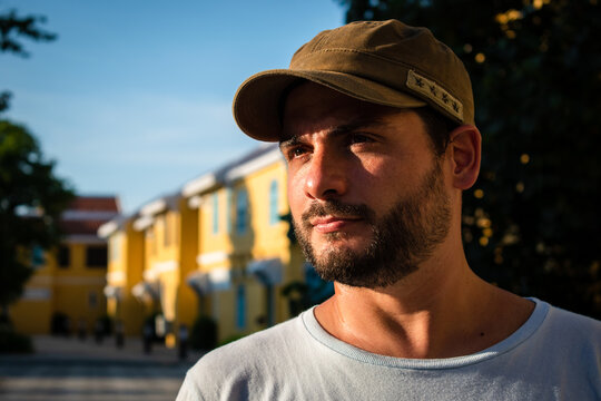Retrato de hombre apuesto con gorra, mirando al atardecer