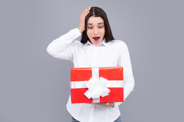 Beautiful girl holding valentines gift. Happy birthday celebration, woman day, christmas. Expressive facial expressions with suprised face. Woman holding gift box and rejoices.