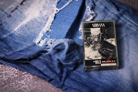 WASHINGTON, USA - September 30 2022 : Nirvana's cassette tape and Ripped jeans or Torn jeans. A symbol of the grunge or Seattle sound.