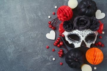 Día de los Muertos day of the dead holiday concept. Sugar skull mask and Mexican party decorations  on dark background. Top view, flat lay