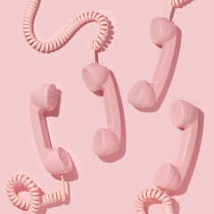 Creative layout with pink retro phone handsets on pastel pink background. 80s or 90s retro fashion...