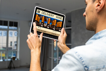 hands holding digital tablet with app delivery food wine screen.