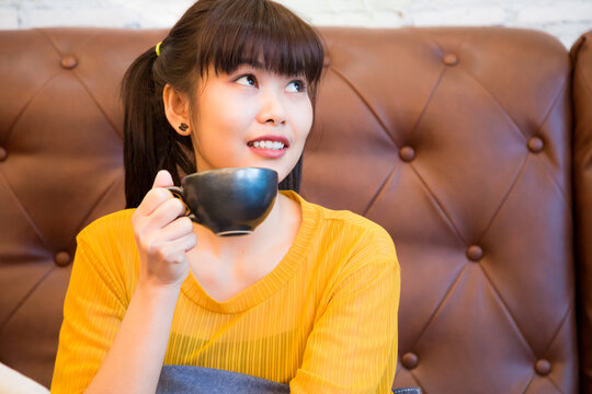 eautiful woman hold cup of hot coffee sitting in vintage cafe
