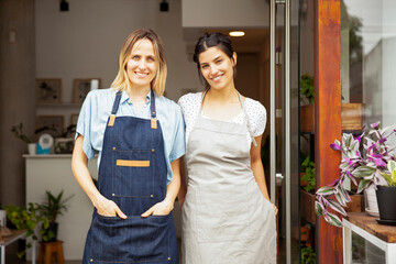 Flower shop coworkers standing at store entrance