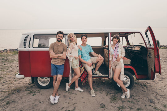 Full Size Photo Of Young Sixties Friends Travel In Minivan Wear T-shirt Shorts Shoes Outdoors