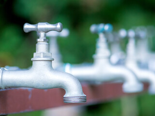  Brass water tap in nature background.