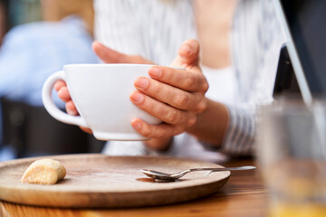 Close up photo of woman's hands holding a cup of coffee