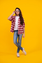 Fototapeta premium Full length of pretty cheerful teenager girl having fun good mood and posing in casual clothes isolated over yellow background.