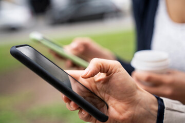 Close-up shot of two women's hands holding smartphones