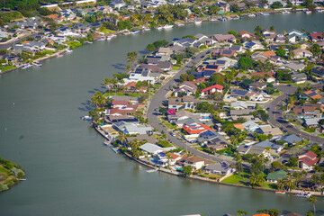 Aerial view of the rooftops of the Hawaii Kai residential neighborhood in the suburbs of Honolulu on O'ahu island - Houses with solar panels on Niumalu Loop next to the Kuapa Pond in Hawaii - obrazy, fototapety, plakaty