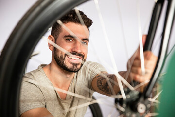 Young adult cmchanic repairing bicycle in workshop