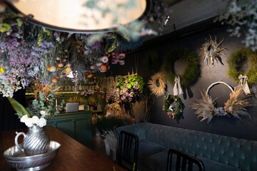 A collection of dry flower bouquets and wreaths displayed on wall of wine-bar