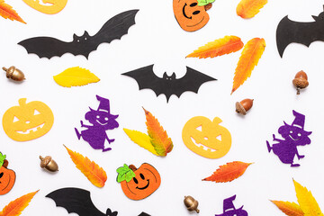 Bright composition with traditional Halloween symbols and bright autumn leaves on white background.
